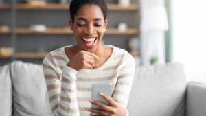 Online Dating App. Young Black Single Woman Using Smartphone At Home