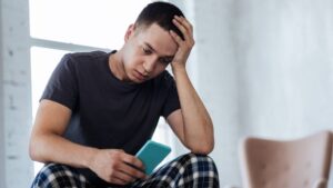 Sad man looking at his phone